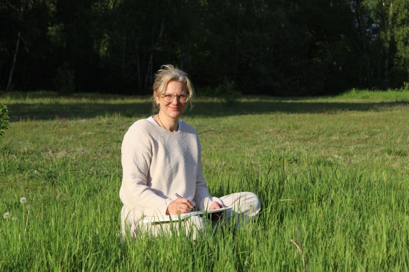 Eine Hand hält eine Pusteblume, Samen fliegen davon